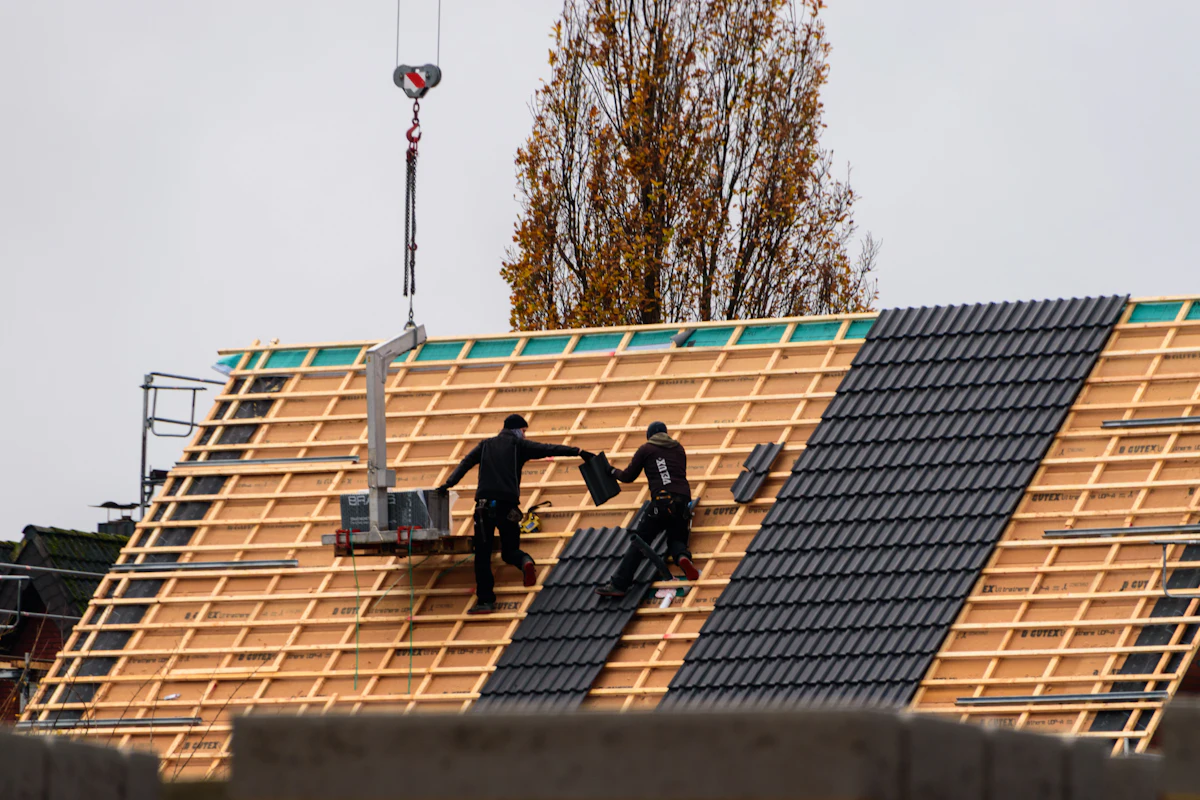 Roofing crew installing a roof on a larger building